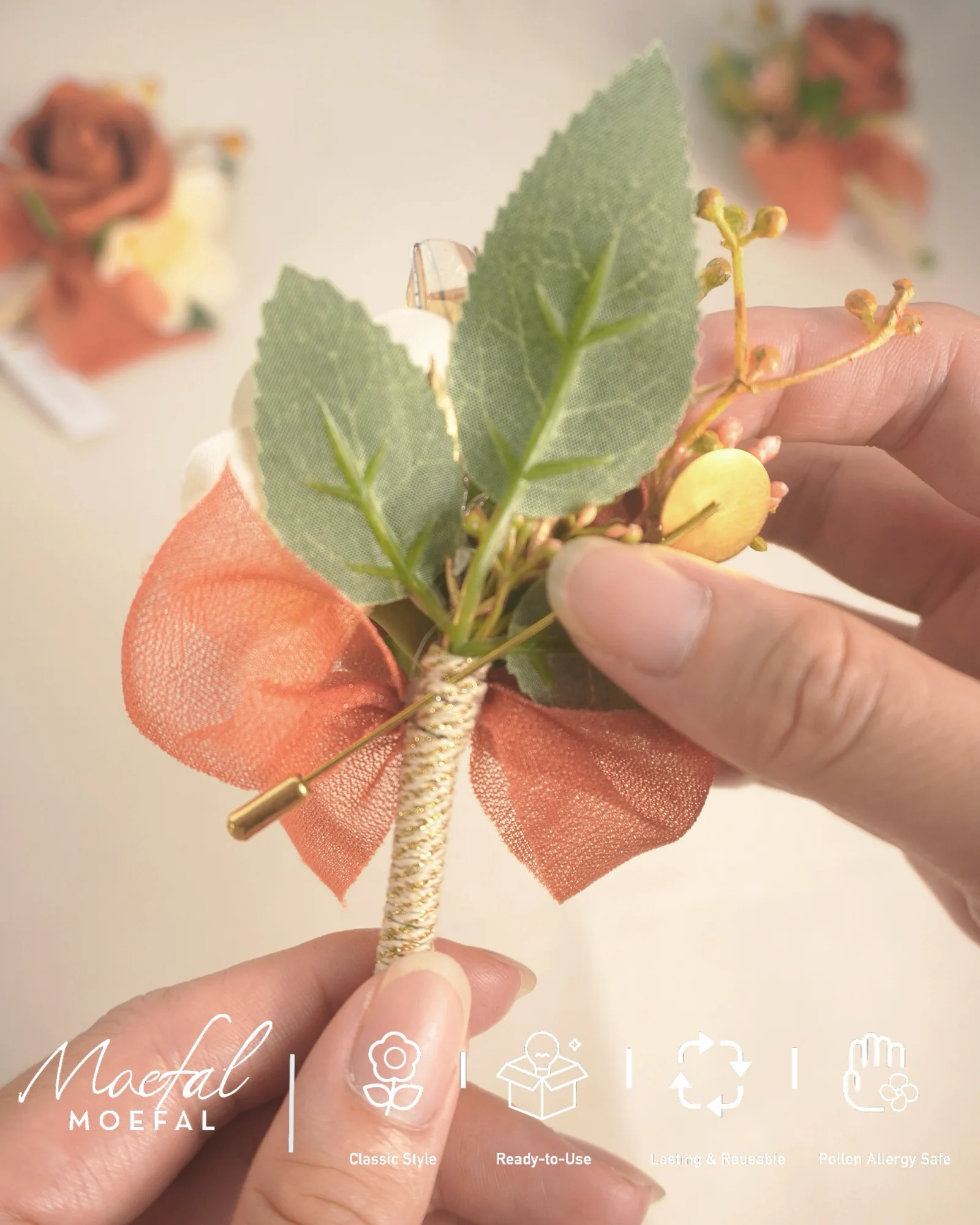 A person's hands holding a terracotta boutonniere to show the attachment pin detail.