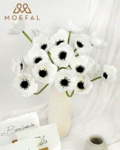 White anemone bouquet in a slender vase sits on a draped table with calligraphy cards.