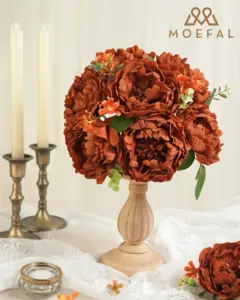 A rust-colored bouquet of artificial terracotta peonies displayed as a vintage table centerpiece.