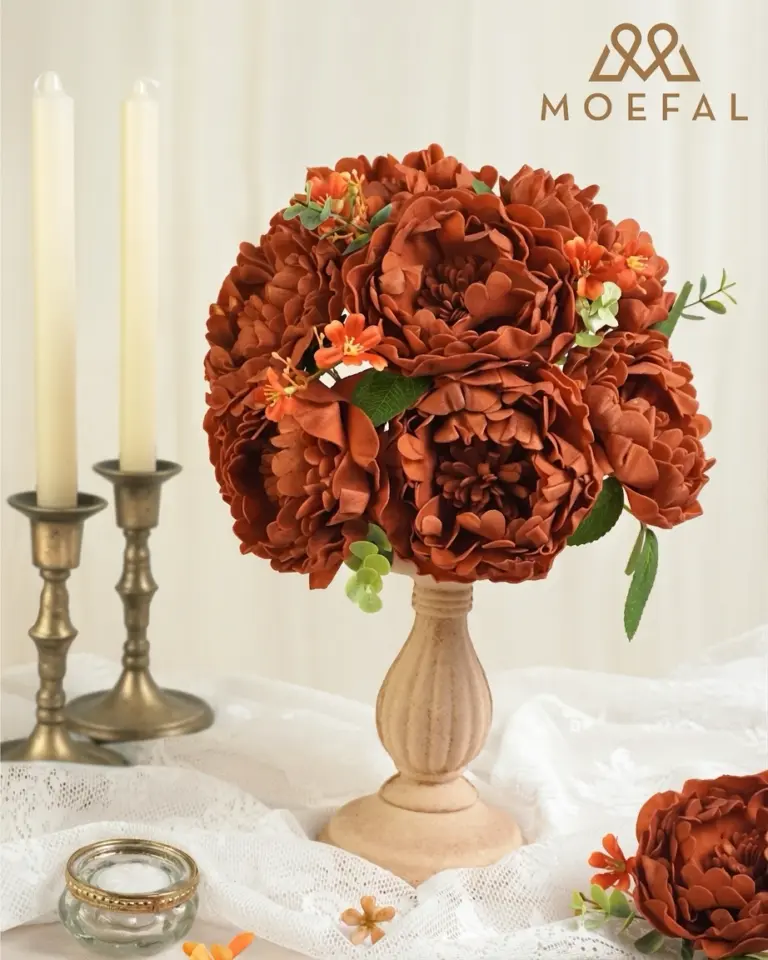 A rust-colored bouquet of artificial terracotta peonies displayed as a vintage table centerpiece.