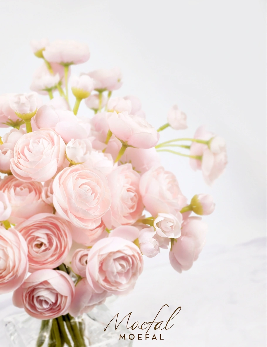 A close-up view of the soft, translucent petals on the blush pink ranunculus bouquet.