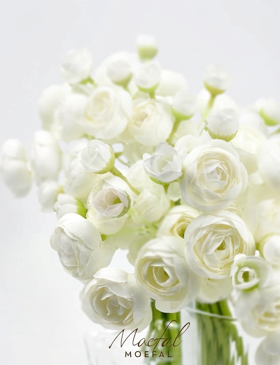 A detailed close-up shot of the delicate white silk petals of bud vase ranunculus.