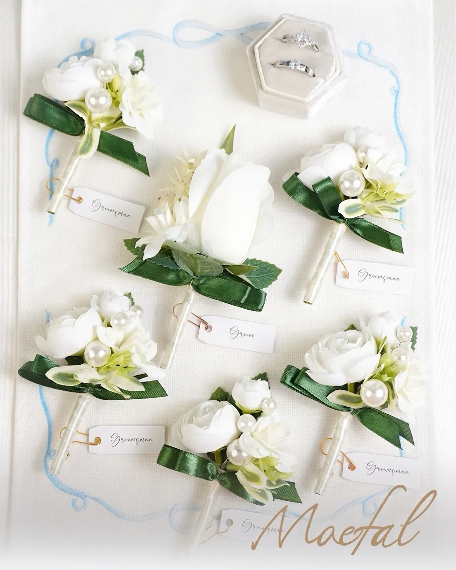 Flat lay of the complete groomsmen boutonniere set next to a wedding ring box.