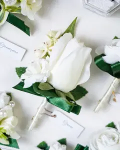Close-up of the groom's white flower boutonniere from a groomsmen boutonniere set.