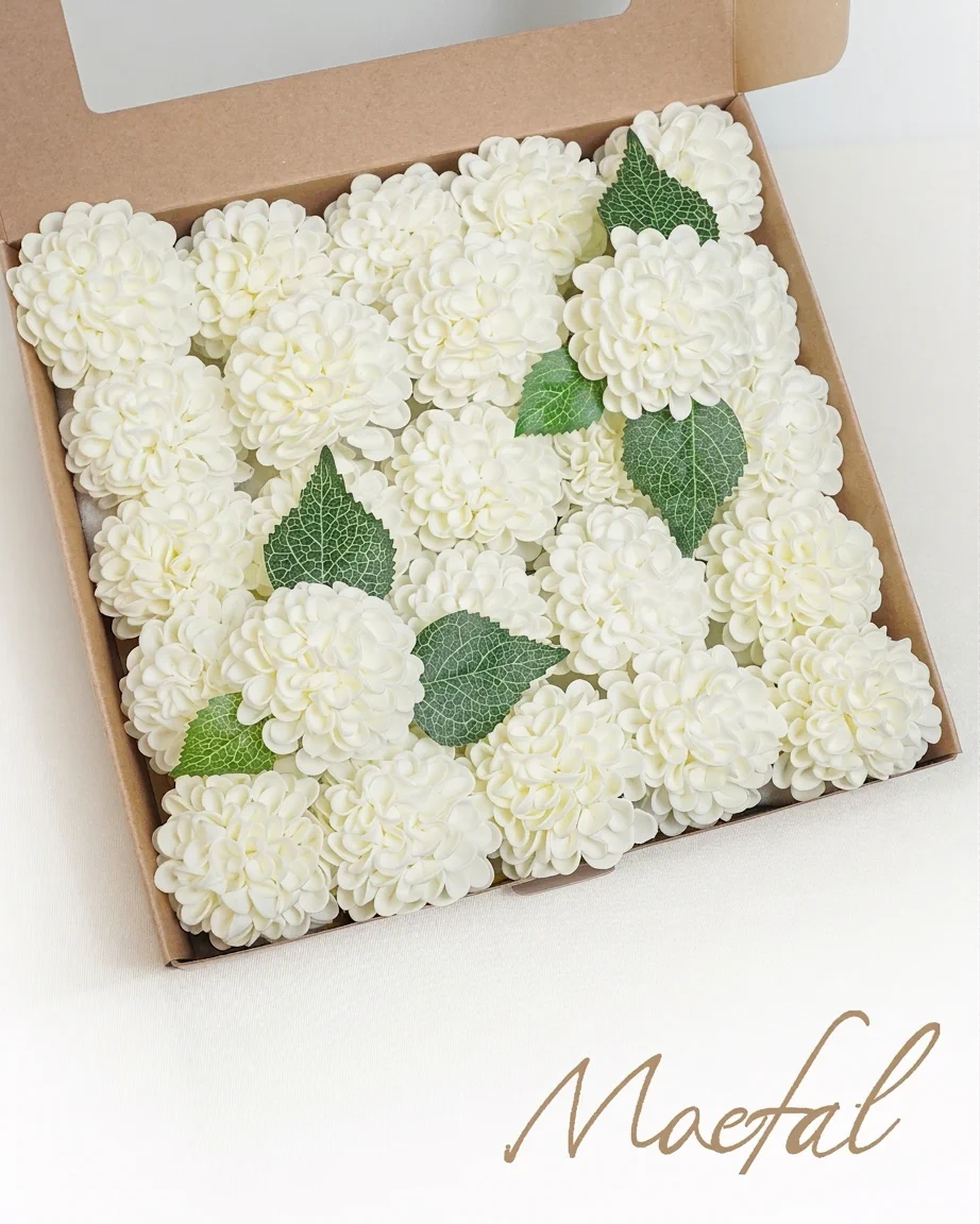 Top-down view of a box filled with ivory dahlia heads, which are realistic wedding flowers.