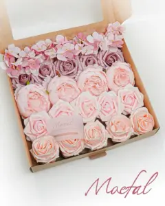 An open kraft box displaying an assortment of pink and blush wedding flowers.