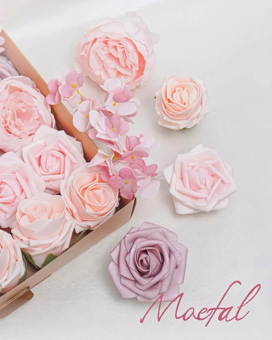 Individual pink and blush wedding flowers laying on a surface next to the box.