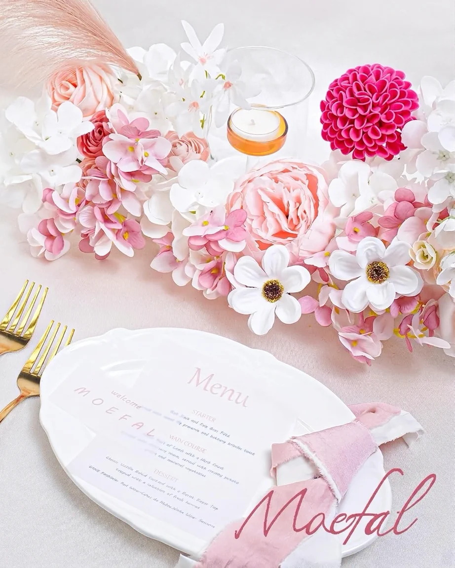 A wedding table setting with a centerpiece made from pink and blush wedding flowers.
