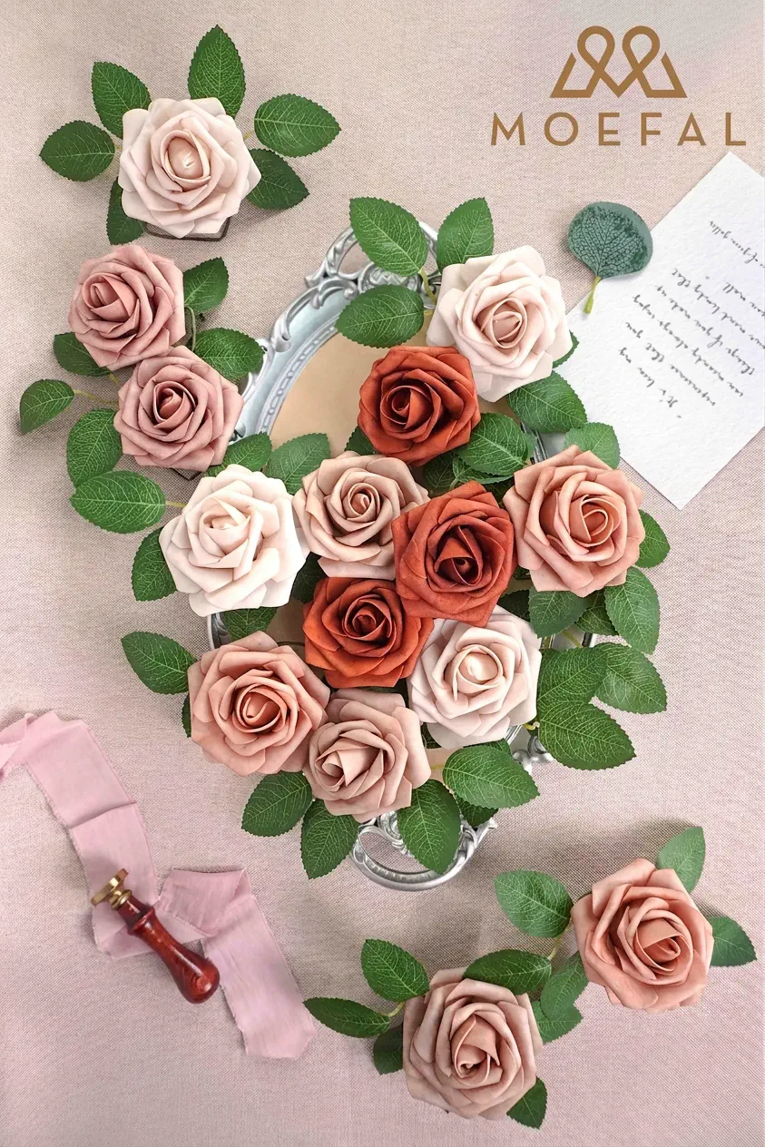 An assortment of roses in a terracotta color palette arranged on a vintage tray.