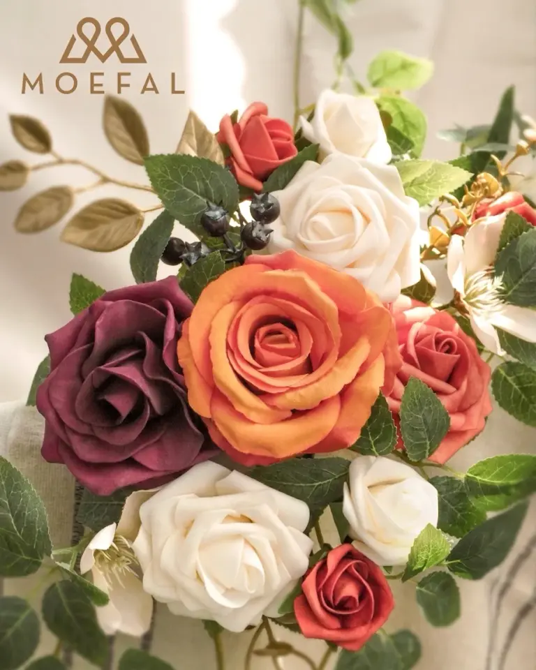 A close-up of terracotta floral swags featuring burnt orange and cream roses.