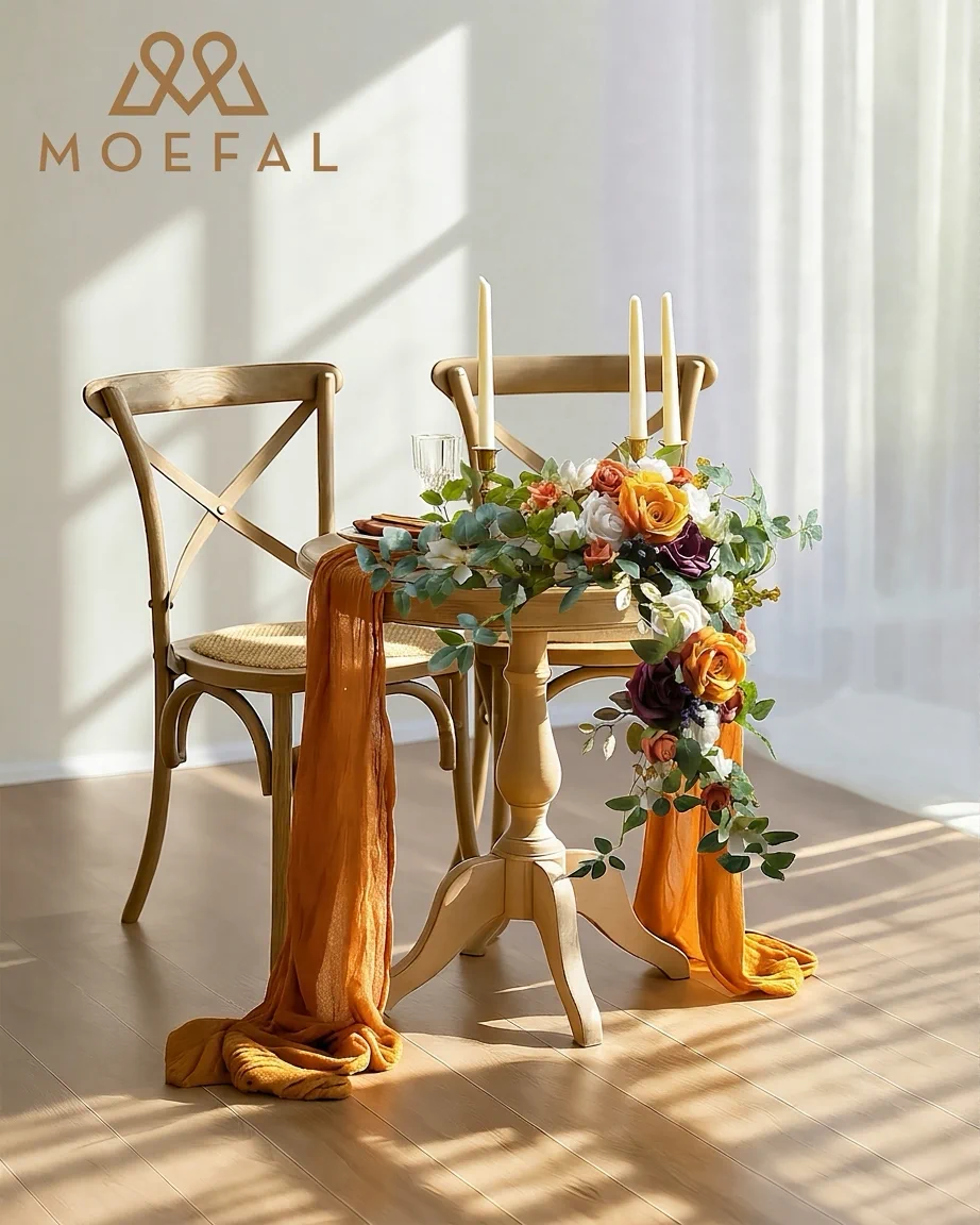 Terracotta floral swags adorning a rustic wooden sweetheart table for a wedding reception.