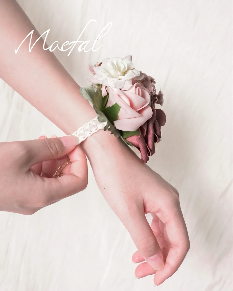 Hands gently adjusting the delicate lace tie of the floral wedding wrist corsage.