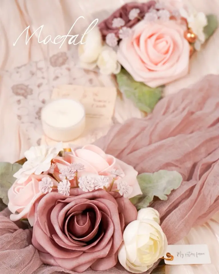 Two dusty rose themed wedding wrist corsages arranged beautifully on soft, romantic fabric.
